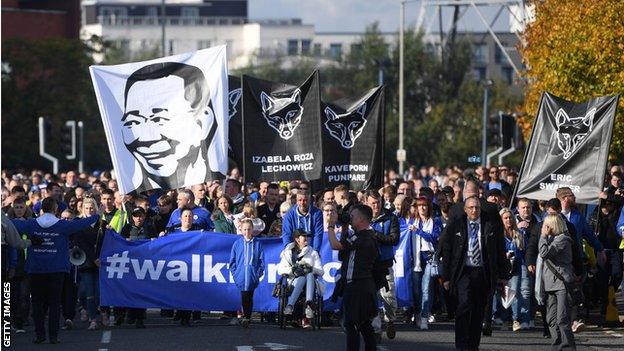 Fans hold up banners during the 'Walk for Vichai'