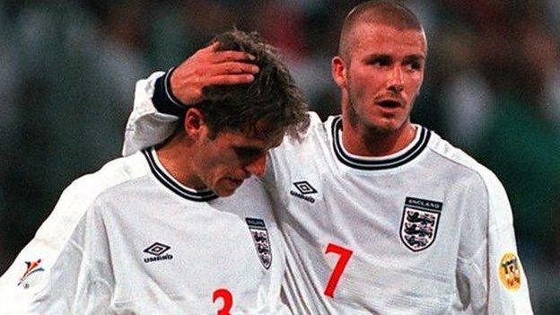 Phil Neville is consoled by David Beckham