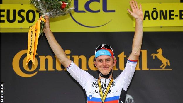 Slovenia's Matej Mohoric puts his hands up in celebration on the podium after winning stage seven of the 2021 Tour de France