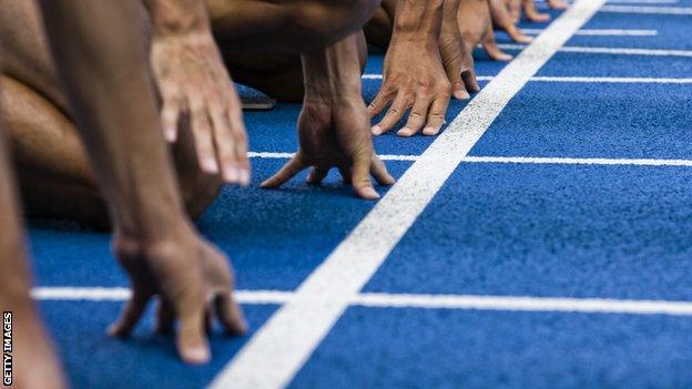 Athletes at the starting line on an athletics track