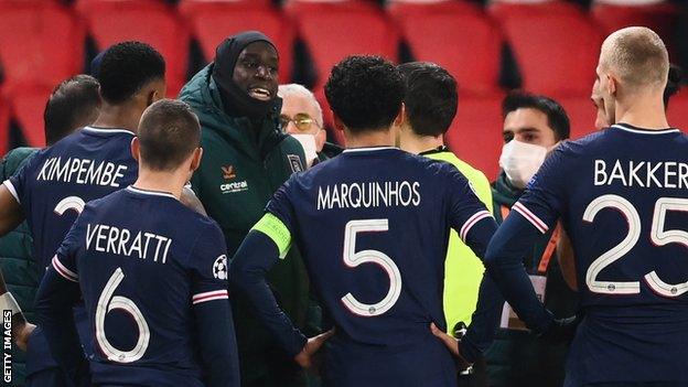 Istanbul forward Demba Ba speaks to the match officials and PSG players