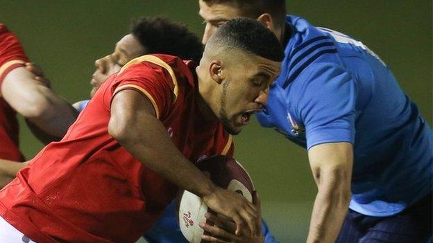 Keelan Giles of Wales is held by Pierre Bruno
