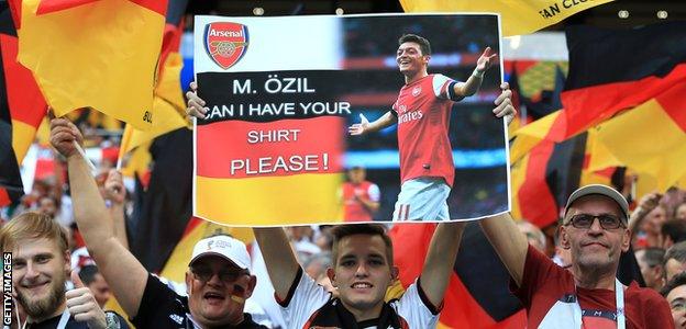 German fans hold up a sign asking for Mesut Ozil's shirt