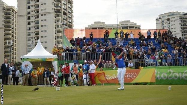 Brazil's Adilson da Silva hits the first Olympic golf shot in 112 years, watched by a sparse crowd