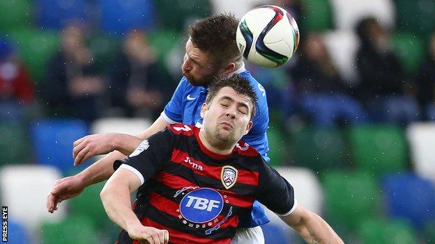 Linfield's Mark Stafford fights out an aerial duel with Coleraine's James McLaughlin