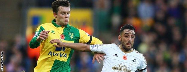 Jonny Howson vies with Neil Taylor