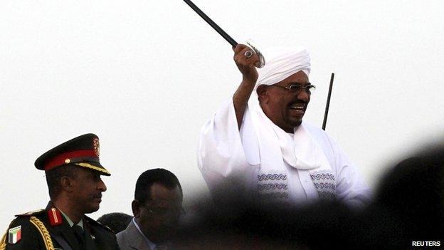 Sudanese President al-Bashir waves to his supporters at the airport in the capital Khartoum