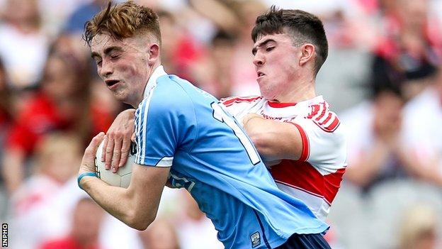 Dublin minor David Lace attempts to shield the ball from Derry's Oran McGill