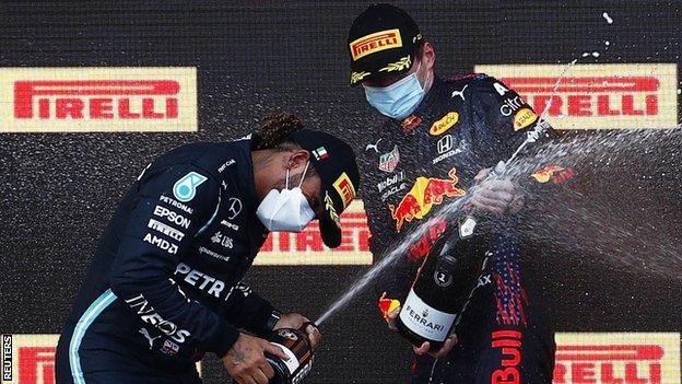 Max Verstappen and Lewis Hamilton spray champagne on the podium