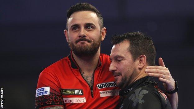 Darts players Joe Cullen (left) and Jonny Clayton (right) embrace after a match