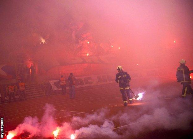 Firemen clear the pitch from flares thrown by Hajduk Split's Ultras Torcida fans during a home match with Zagreb in February 2013