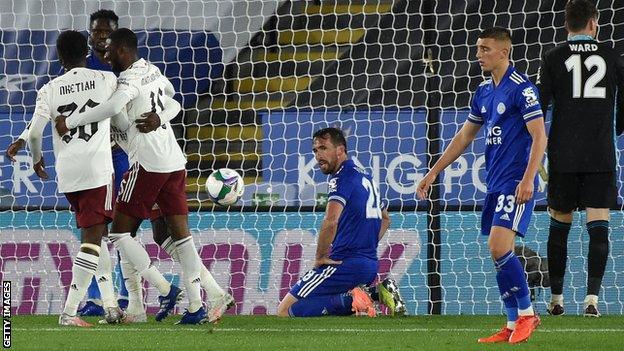 Arsenal celebrate as Christian Fuchs looks on after scoring an own goal