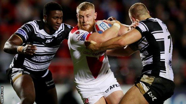 Luke Thompson holds off two Hull defenders to score a try for St Helens