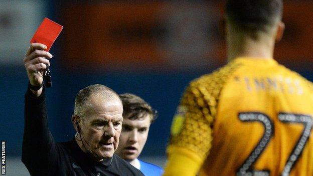 Referee Graham Salisbury shows a straight red card to Ryan Inniss