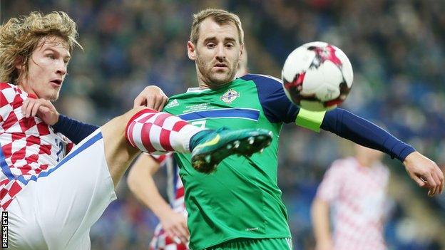 Tin Jedjav challenges Niall McGinn who captained Northern Ireland on the occasion of his 50th cap