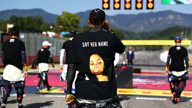 Lewis Hamilton (pictured from behind) wearing a t-shirt featuring a photo of Breonna Taylor and the words 'say her name'