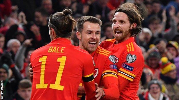 Joe Allen (R) celebrates Euro 2020 qualification with Wales team-mates Aaron Ramsey and Gareth Bale