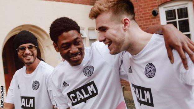 Members of the FC Not Alone squad share a joke wearing their kit