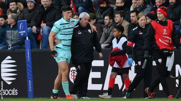 Louis Rees-Zammit is helped from the field