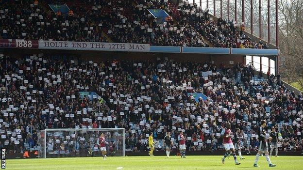 Villa fans stand to protest in the 74th minute