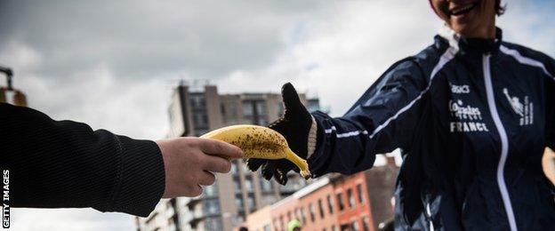 A volunteer giving a banana to a runner