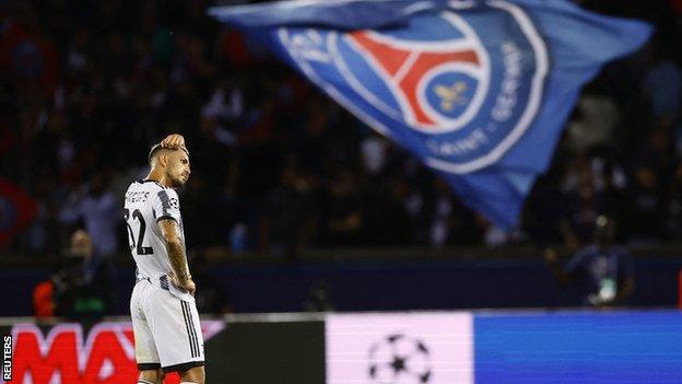 Juventus' Leandro Paredes and a Paris St-Germain flag