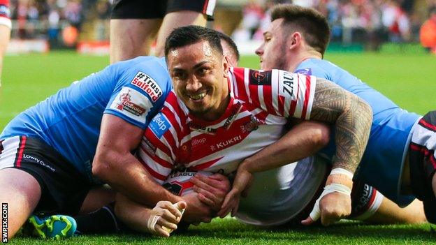 Harrison Hansen slides over the try line under a challenge from two Salford tacklers