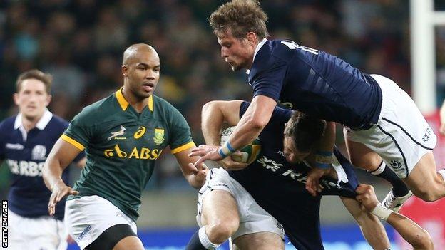 Cornal Hendricks of South Africa tackles Scotland's Tommy Seymour as Peter Horne falls over the top of them during the Test at Nelson Mandela Bay Stadium in 2014