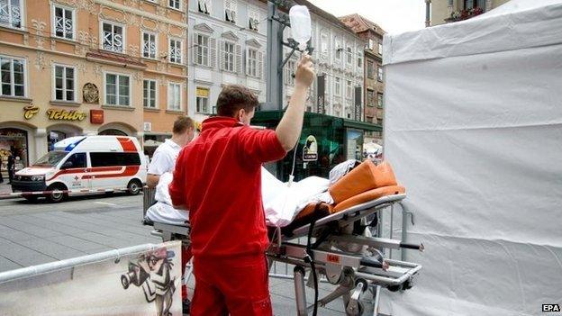 Paramedics treat a person at the scene where an SUV drove into pedestrians in the city center of Graz, Austria, 20 June 2015
