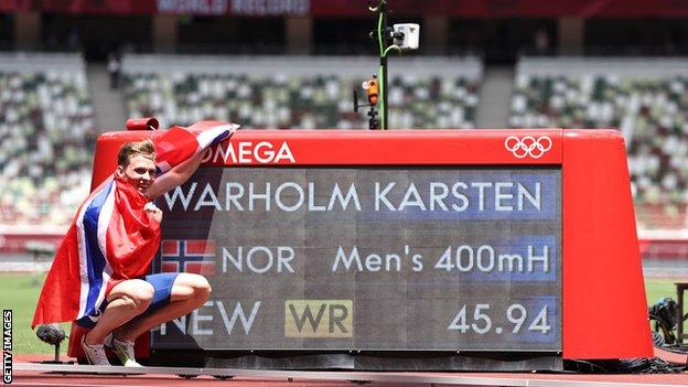 Karsten Warholm poses with the world record time