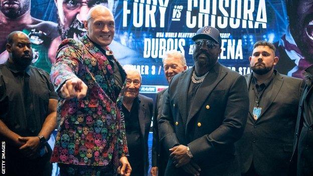 Tyson Fury points during a face off with Derek Chisora