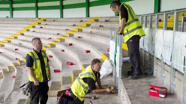 Workers install the new safe-standing barriers at Celtic Park