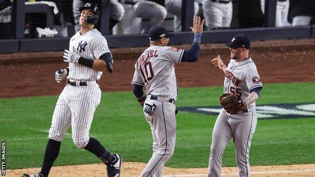 New York Yankees outfielder Aaron Judge is thrown out at first base as Yuli Gurriel and Ryan Pressly celebrate the Houston Astros' win