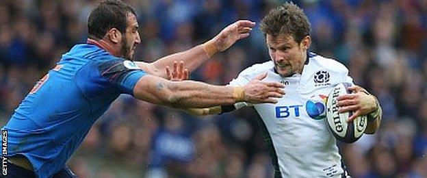 Peter Horne holds off a French tackler in Scotland's victory