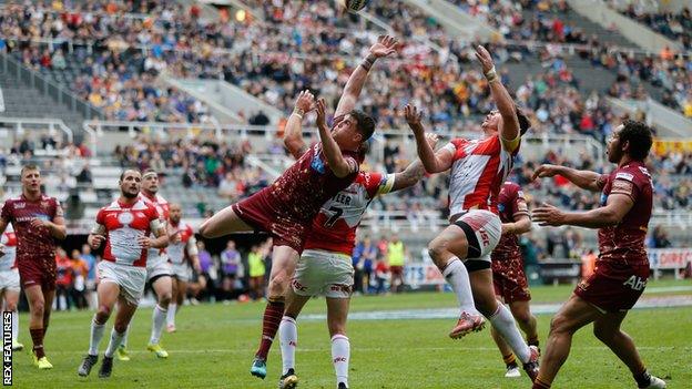 Huddersfield and Catalans players go up for a high ball