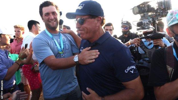 Jon Rahm congratulates Phil Mickelson on his victory