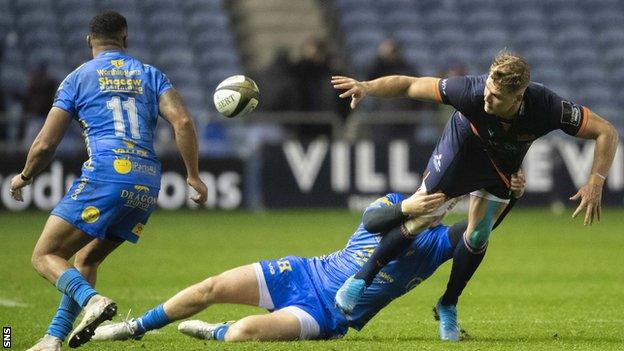 Edinburgh wing Duhan van der Merwe off-loads the ball against Dragons