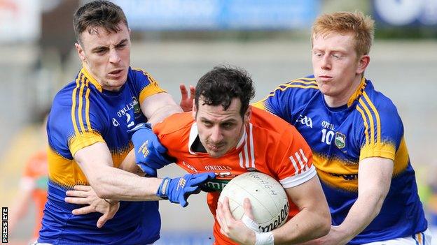 Two Tipperary players get to grips with Orchard forward Jamie Clarke at the Athletic Grounds