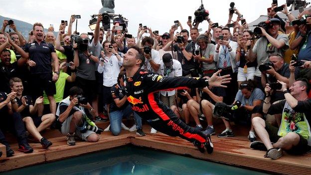 Daniel Ricciardo dives into a pool after his win at the Monaco Grand Prix