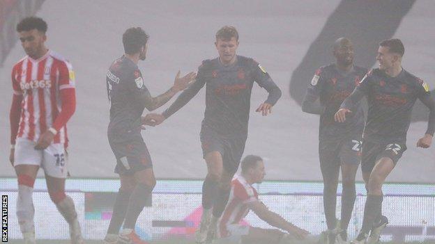 Nottingham Forest celebrate an own goal from Stoke's James Chester (sat down)