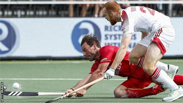 Belgium's Sebastien Dockier fights for the ball with England's Jack Waller