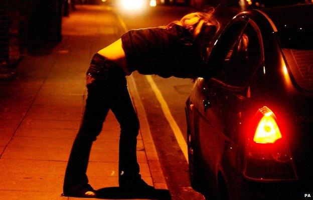 A prostitute talks to a car driver