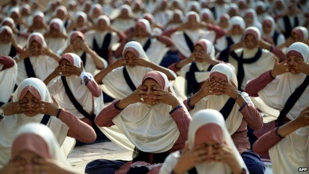 Indian school students attend a yoga workshop conducted by teachers from The Sri Sri Ravi Shankar Institute at The FD Higher Secondary School in Ahmedabad on June 16, 2015