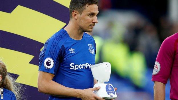 Everton captain Phil Jagielka carrying a robot mascot on to the pitch