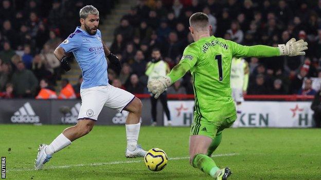 Manchester City striker Sergio Aguero taps past Sheffield United's Dean Henderson