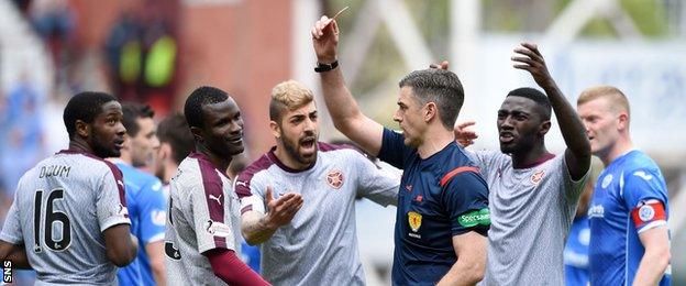 Referee Greg Aitken shows the red card to Hearts' Abiola Dauda