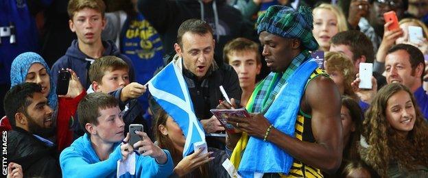 Usain Bolt of Jamaica greets fans as he celebrates winning gold in the men's 4x100 metres relay final at Hampden Park