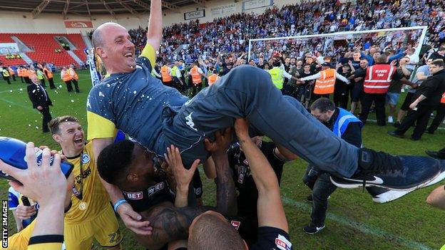 Wigan boss Paul Cook celebrates winning the League One title