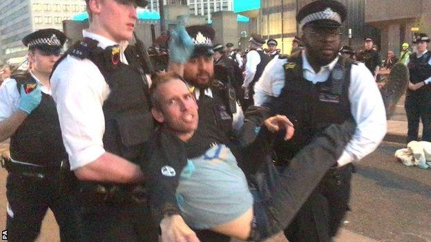 Etienne Stott is carried by police after being arrested