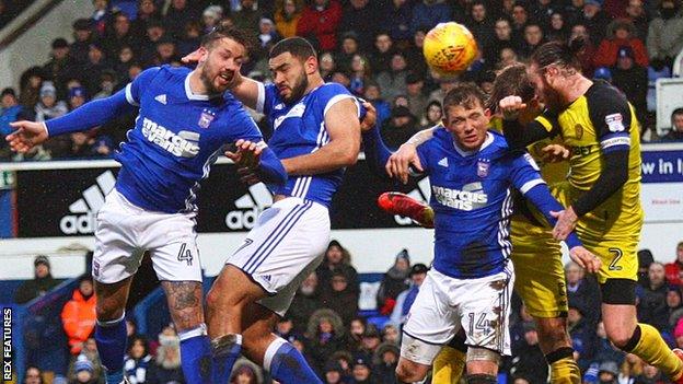 Ipswich and Burton players compete for a header